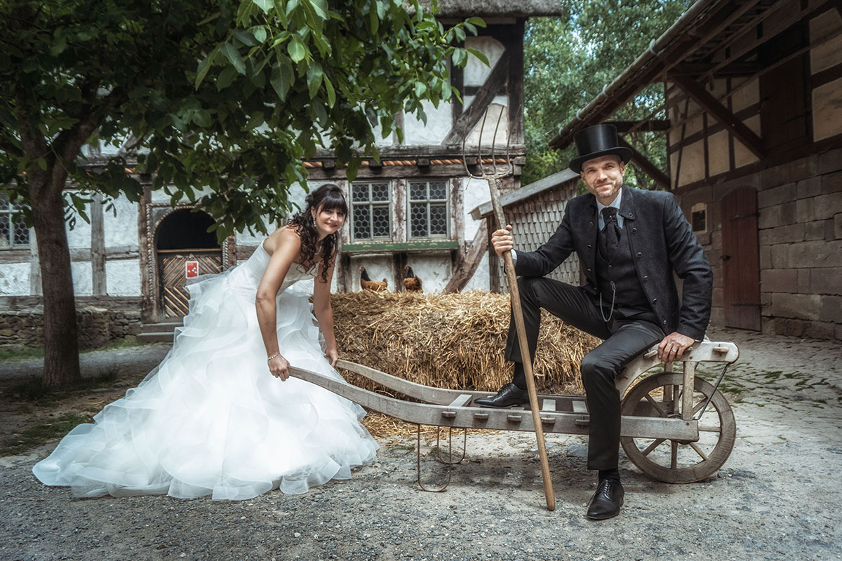 Hochzeitspaar als Portraitfotografie auf einem Bauernhof arbeitend - Hochzeitsfotografie